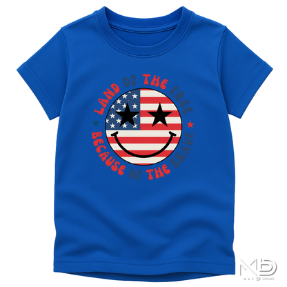 Land of the Free Because of the Braves Patriotic Smiley Face Shirt | American Flag Happy Face Tee | Fourth of July Graphic T-Shirt | USA Independence Day Shirt